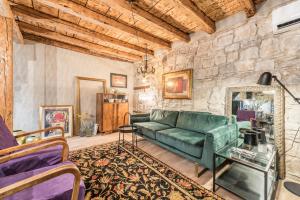 a living room with a green couch and a stone wall at Livo Disno 12 in Split