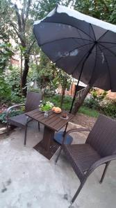- une table avec un parasol, une table et des chaises dans l'établissement Newly renovated house, à Tbilissi