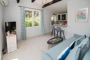 a living room with a blue couch and a tv at Charmante petite maison a l'éntrée de Saint Tropez in Saint-Tropez
