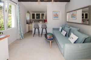 a living room with a blue couch and a table at Charmante petite maison a l'éntrée de Saint Tropez in Saint-Tropez