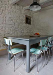 una mesa con 4 sillas y un bol de fruta en SASSO AL MELO - Apartments, en Cutigliano