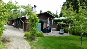 une petite maison avec une terrasse et un bâtiment dans l'établissement Ferienhaus zwischen Wald und See, à Möhnesee