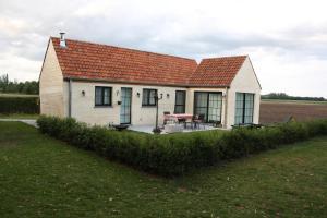 una pequeña casa blanca con techo rojo en Vakantiehuis Schardauw, en Damme