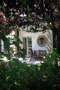 a patio with two chairs and a mirror on a building at Nostos Hotel in Afitos