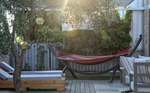 a hammock in a backyard with a fence at Nostos Hotel in Afitos
