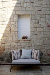 a couch in front of a brick wall with a window at Nostos Hotel in Afitos