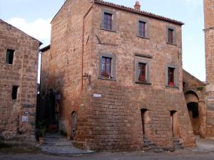 um velho edifício de tijolos com janelas do lado em Civita B&B em Bagnoregio