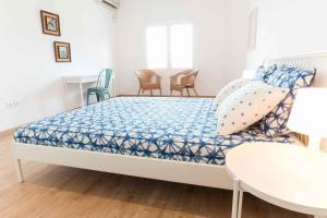 a bedroom with a bed and chairs and a table at Casa Delfín on Corralejo center beach: Wifi, Netflix, aircon... in Corralejo
