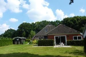 una casa con un patio de hierba delante de ella en De Eurostee - Boerderij appartementen en Schoonloo