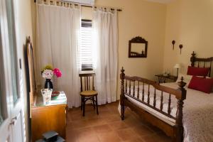 a bedroom with a bed and a desk and a window at Los Olivos in Playa de Santiago