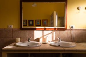 a bathroom with two sinks and a large mirror at Los Olivos in Playa de Santiago +21 photos
