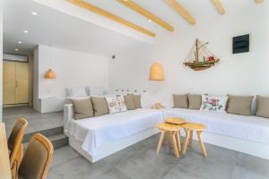 ein weißes Wohnzimmer mit einem weißen Sofa und Tischen in der Unterkunft Beach Suite Syrma in Pachaina