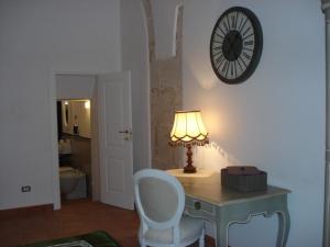 a desk with a lamp and a clock on a wall at Residenza Levante in Syracuse