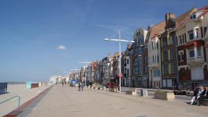 a street with buildings and people walking on the sidewalk at Passionné de la plage in Dunkerque