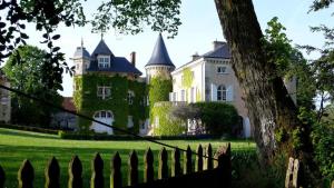 ein altes Herrenhaus mit einem Zaun davor in der Unterkunft Saint Victor La Grand' Maison in Ingrandes