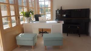 een kamer met een bureau met een laptop en 2 krukken bij Sirocco Apartments in Chersonissos