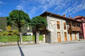 un edificio de piedra con un árbol delante de él en Apartamentos Spa Cantabria Infinita, en Cillorigo de Liébana