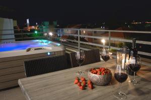 a table with wine glasses and a bowl of fruit on a balcony at Villa Kovac in Zadar