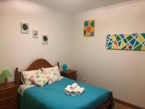 a bedroom with a blue bed with two rolls at Apartamento Parque Urbano in Ponta Delgada