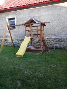 a wooden play set with a slide and a playground at Chalupa u Beňov in Lúčky