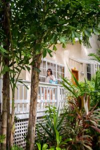 Una mujer mirando por la ventana de un edificio en Paradise Beach Hotel en West Bay