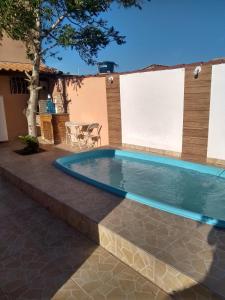 una piscina en un patio con mesa y sillas en Casa com piscina e churrasqueira, en Iguaba Grande