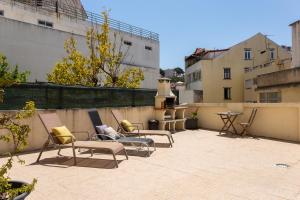 a patio with chairs and tables on a rooftop at Graca House in Lisbon