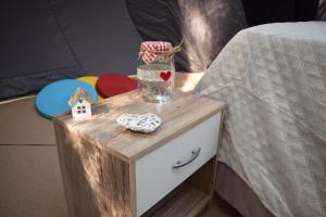 een nachtkastje met een pot erop naast een bed bij Bubble room sul tetto della Puglia in Biccari
