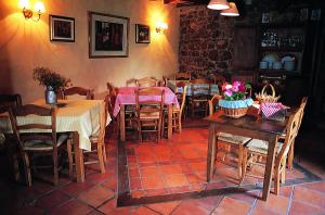 un comedor con mesas y sillas y una pared de ladrillo en Posada la Trebede en Perrozo