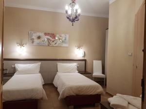 Cette chambre comprend deux lits et un lustre. dans l'établissement Agriturismo Masseria Mascitelli, à Orta Nova
