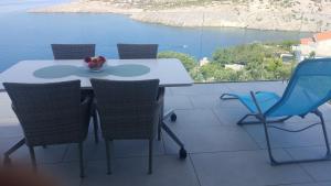 a table and chairs with a view of the water at Mayana in Cesarica