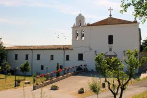 a church with a white building with a steeple at Bubble room sul tetto della Puglia in Biccari