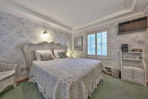a bedroom with a large bed and a large window at Silver Maple Inn and The Cain House Country Suites in Bridgeport