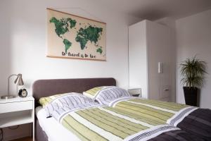 FeWo Alte Mainbrücke في فورتسبورغ: غرفة نوم مع سرير مع خريطة على الحائط