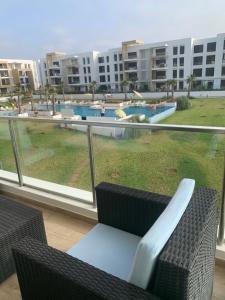 d'un balcon avec des chaises et une vue sur la piscine. dans l'établissement Presigia plage des nation Vacation Home, à Sidi Bouqnadel