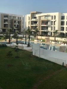 - une vue sur un complexe d'appartements avec une piscine dans l'établissement Presigia plage des nation Vacation Home, à Sidi Bouqnadel