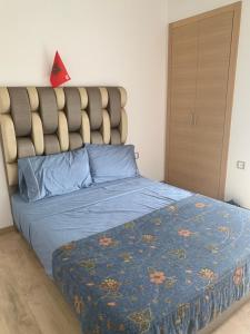 - une chambre avec un lit et une couette bleue dans l'établissement Presigia plage des nation Vacation Home, à Sidi Bouqnadel