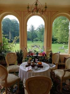 a room with a table and chairs and two windows at Château de la Bucaille - entier in Aincourt