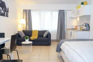 a bedroom with a bed and a couch and a table at nice central studio in Luxembourg