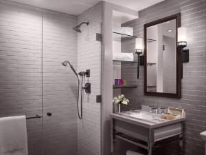 a bathroom with a sink and a shower with a mirror at Plaza la Reina in Los Angeles