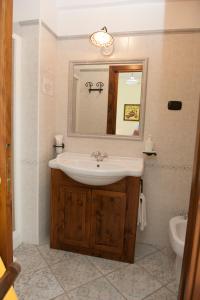 a bathroom with a sink and a mirror and a toilet at Casa Vacanze - B&B Il Tempone in Prignano Cilento