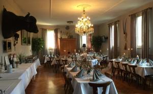 a dining room with tables and chairs and a chandelier at Murmeltier in Hausen im Tal