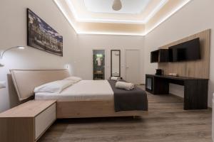 una camera con un grande letto e una televisione di Sammartino suite a Palermo