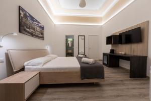 a bedroom with a large bed and a television at Sammartino suite in Palermo
