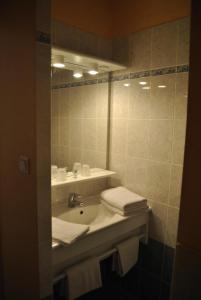a bathroom with a sink and a mirror at Hôtel Auberge de La Nauze in Sagelat