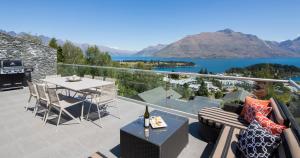 a balcony with a table and a view of a lake at Papillon, a Relax it's Done luxury holiday home in Queenstown