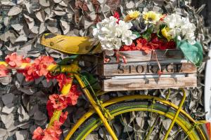 a yellow bike with a wooden crate with flowers on it at Il Viaggio in Diano Marina