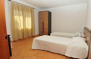 a bedroom with two beds and a dresser in it at Gallo Spot in San Teodoro