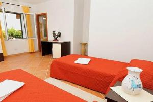 1 dormitorio con cama roja y mesa en Gallo Spot en San Teodoro
