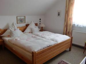 ペルツァーハケンにあるKrohn Trauteのベッドルーム1室(大型ベッド1台、白いシーツ、枕付)